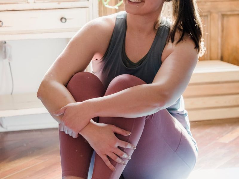 Woman practicing yoga in a bright room during morning hours